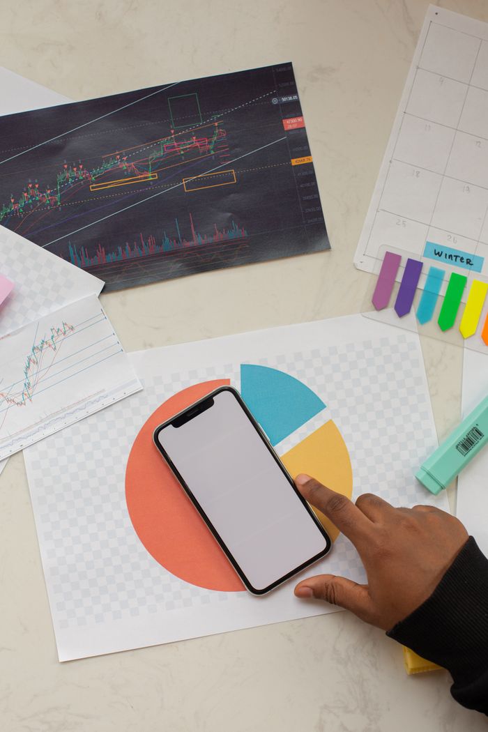 gallery-02 Creative business workspace featuring a smartphone mockup and financial charts.